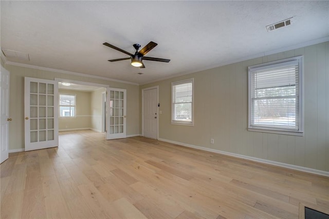 unfurnished room featuring french doors, ceiling fan, ornamental molding, and light wood-type flooring