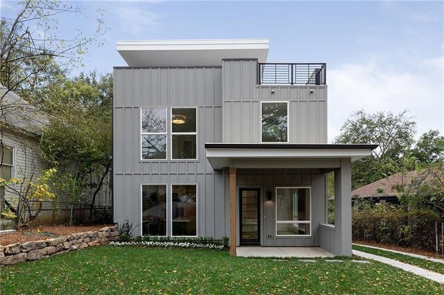 back of house with a patio and a yard