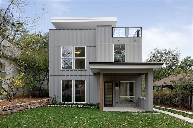 back of property featuring a yard and a balcony