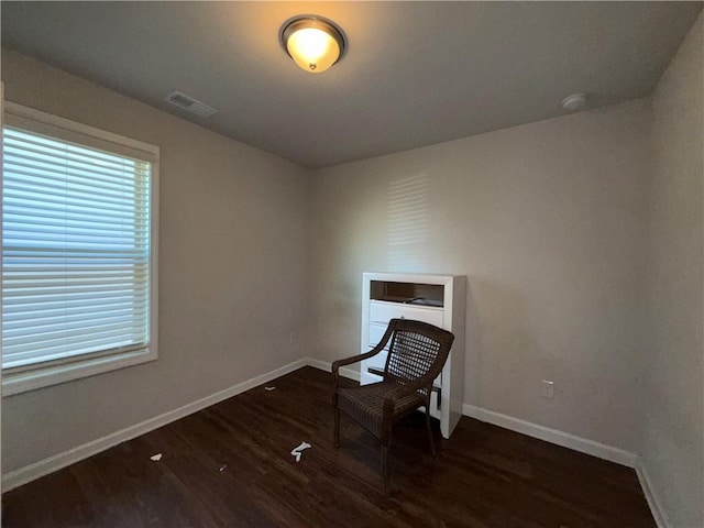 spare room with visible vents, baseboards, and wood finished floors