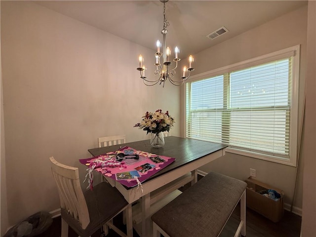 dining room with baseboards, visible vents, and a notable chandelier