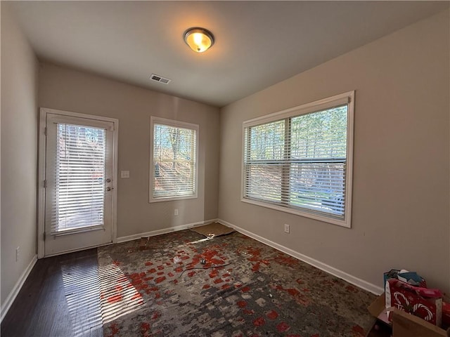 doorway with baseboards and visible vents