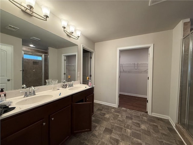 full bath with a walk in closet, a sink, visible vents, and a shower stall