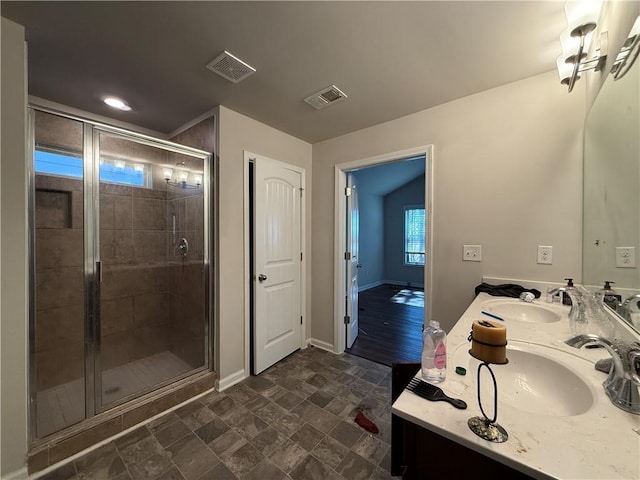 bathroom featuring a stall shower, a sink, and visible vents