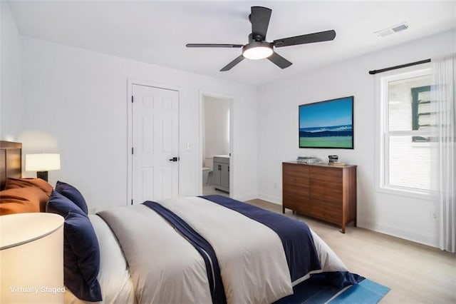 bedroom featuring ceiling fan, ensuite bathroom, and light hardwood / wood-style floors