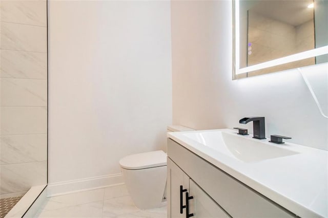 bathroom with vanity, toilet, and tiled shower