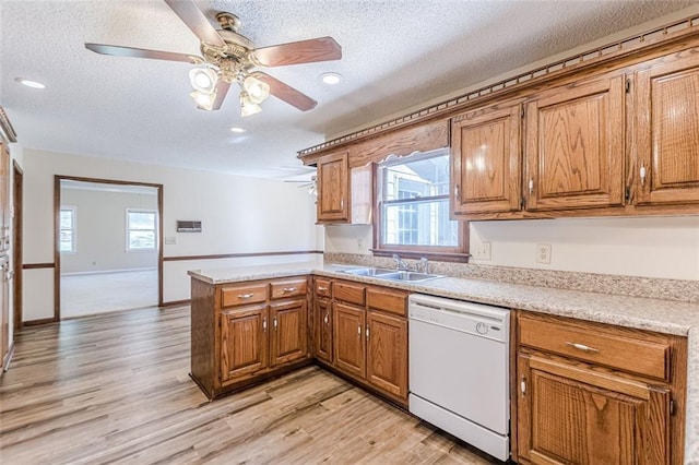 kitchen featuring sink, a textured ceiling, kitchen peninsula, and dishwasher