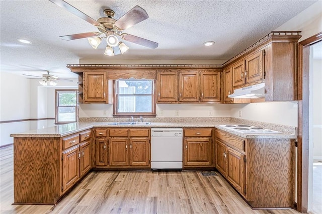 kitchen with white appliances, kitchen peninsula, sink, and a textured ceiling