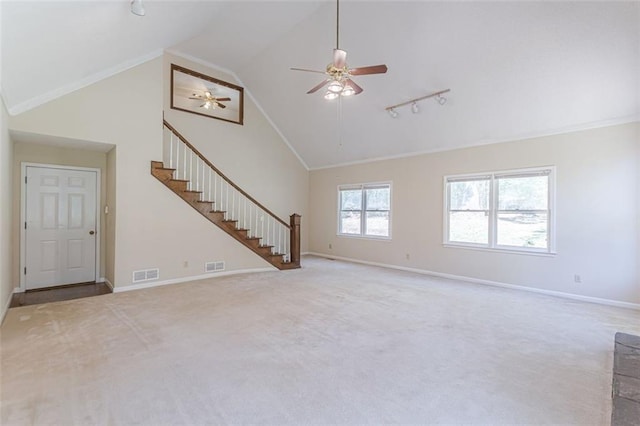 unfurnished living room with high vaulted ceiling, track lighting, ceiling fan, crown molding, and light carpet