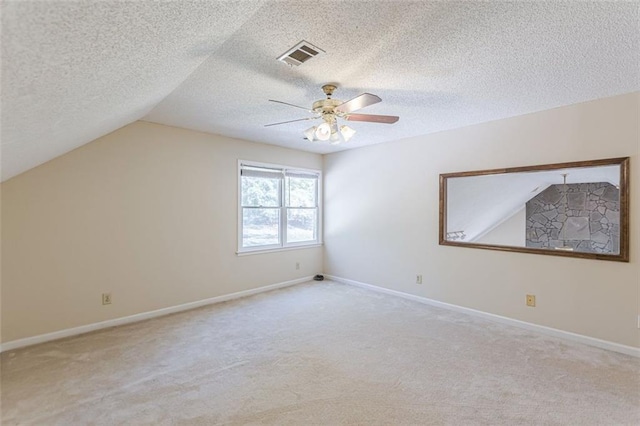 additional living space featuring ceiling fan, light colored carpet, vaulted ceiling, and a textured ceiling