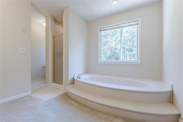 bathroom featuring independent shower and bath and a textured ceiling