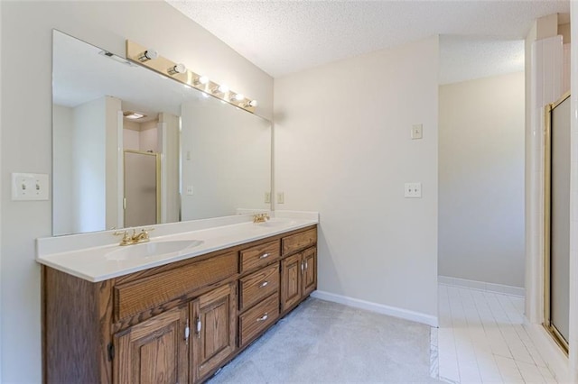 bathroom with vanity, a textured ceiling, and walk in shower