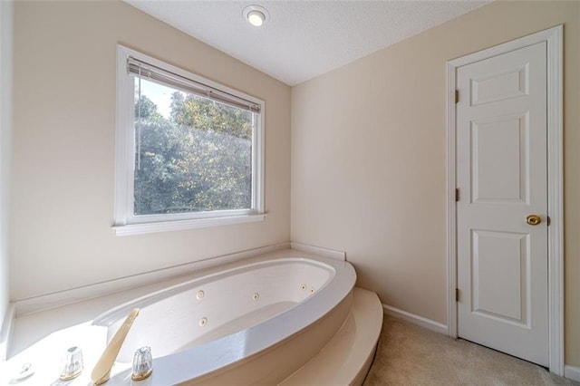 bathroom featuring a tub and a textured ceiling