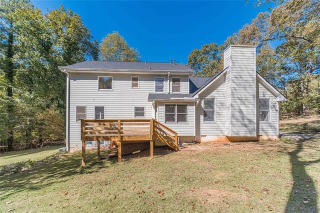 back of house with a deck and a lawn