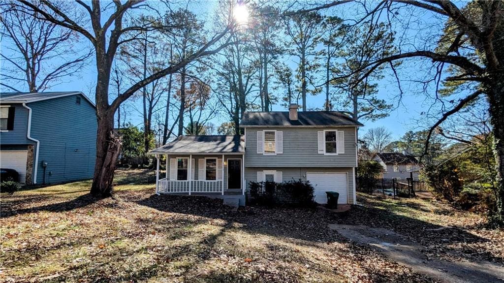 tri-level home featuring covered porch and a garage