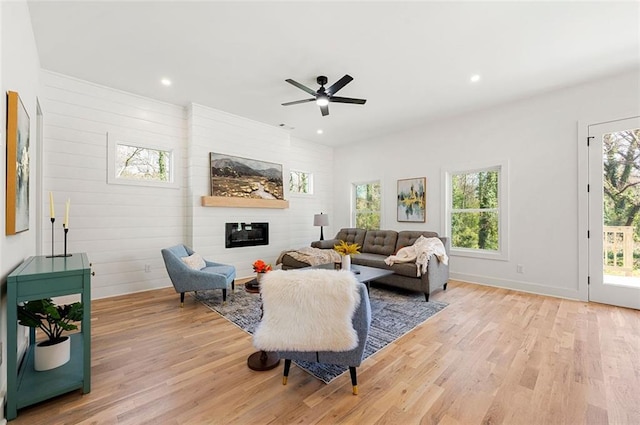 living area featuring a ceiling fan, recessed lighting, light wood-style floors, and a large fireplace