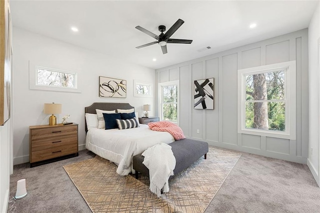 bedroom featuring visible vents, light carpet, recessed lighting, a decorative wall, and a ceiling fan