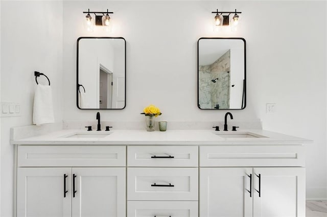 full bathroom with double vanity, an enclosed shower, and a sink