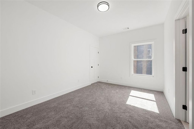 spare room featuring visible vents, baseboards, and carpet