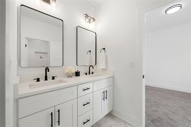 bathroom featuring double vanity, marble finish floor, baseboards, and a sink