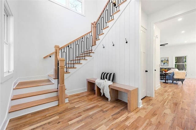 stairway with recessed lighting, a healthy amount of sunlight, baseboards, and wood finished floors