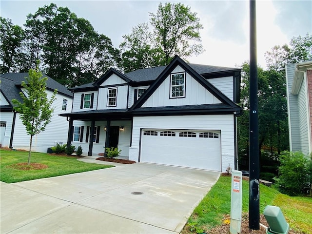 1540 Ox Bridge Ct, Lawrenceville, GA 30043 - view of front facade with covered porch, driveway, a front yard, and board and batten siding