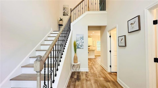 1540 Ox Bridge Ct, Lawrenceville, GA 30043 - stairway featuring wood finished floors, a towering ceiling, and baseboards