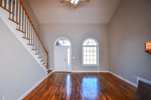 entryway with a towering ceiling, dark hardwood / wood-style floors, and ceiling fan