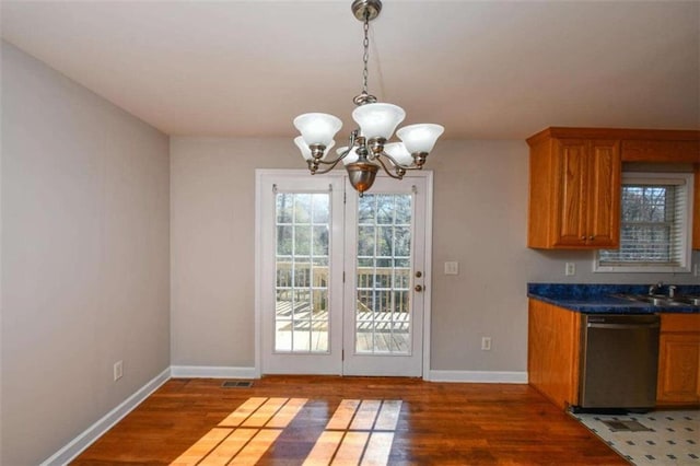 interior space with sink, dark hardwood / wood-style flooring, stainless steel dishwasher, a notable chandelier, and decorative light fixtures