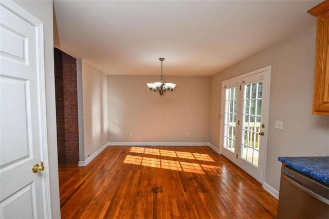 unfurnished dining area with french doors, dark hardwood / wood-style floors, and a notable chandelier