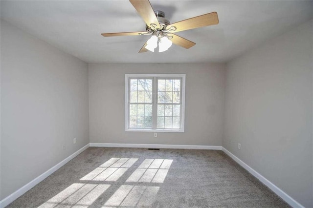 carpeted spare room featuring ceiling fan