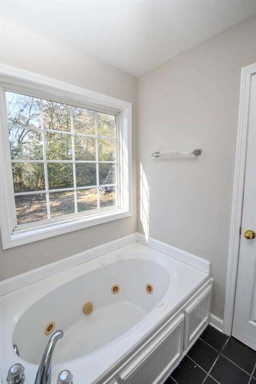 bathroom featuring tile patterned flooring, plenty of natural light, and a tub