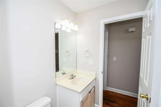 bathroom featuring vanity, hardwood / wood-style flooring, and toilet