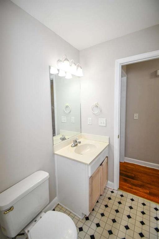 bathroom featuring vanity, hardwood / wood-style flooring, and toilet