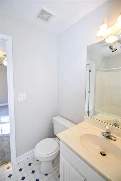 bathroom featuring a shower, vanity, and toilet