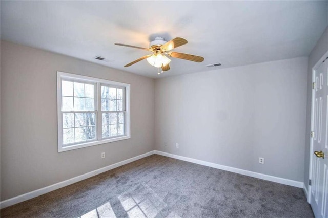 empty room featuring dark colored carpet and ceiling fan