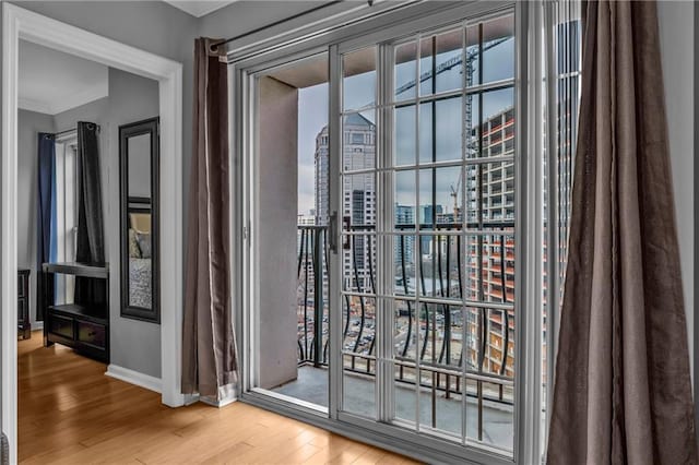 doorway to outside featuring hardwood / wood-style floors and ornamental molding