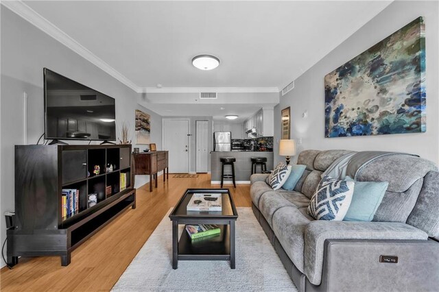 199 14th St NE Unit 2010, Atlanta, GA 30309 - living room featuring visible vents, ornamental molding, and light wood-style flooring