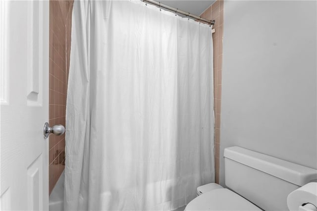 199 14th St NE Unit 2010, Atlanta, GA 30309 - bathroom featuring toilet and shower / bathtub combination with curtain