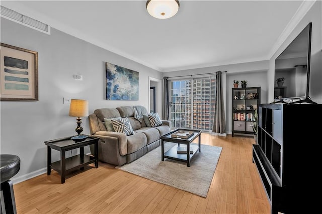199 14th St NE Unit 2010, Atlanta, GA 30309 - living area featuring light wood-style flooring, visible vents, baseboards, and ornamental molding