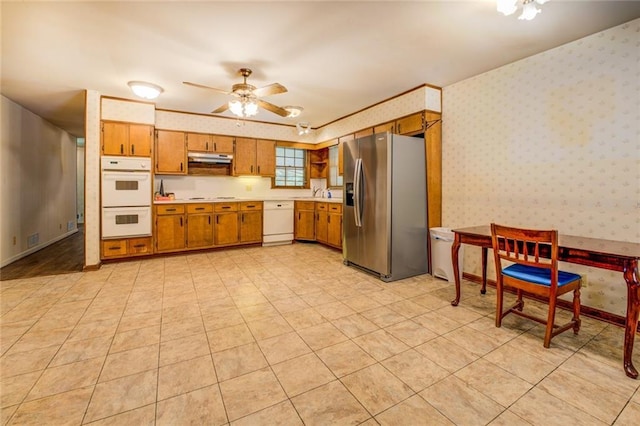 1850 Francis Rd SW, Conyers, GA 30094 - kitchen with brown cabinetry, white appliances, wallpapered walls, light countertops, and a ceiling fan