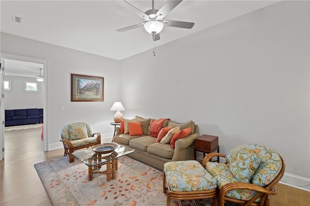 living room featuring light hardwood / wood-style flooring and ceiling fan