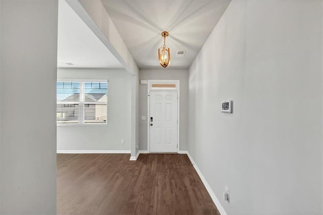 foyer entrance with visible vents, baseboards, and wood finished floors