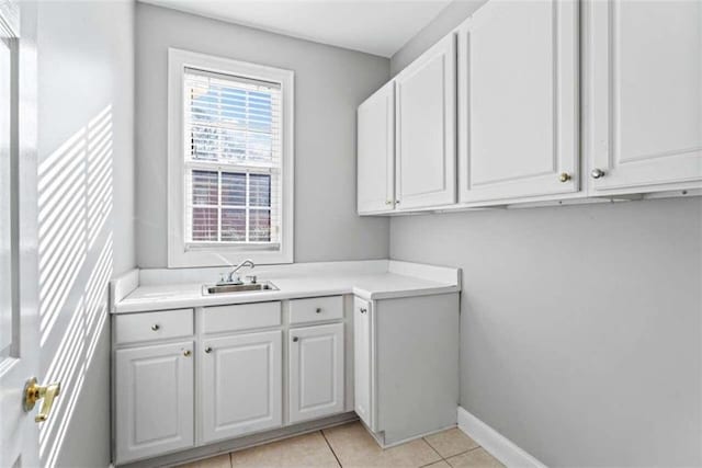 clothes washing area featuring sink and light tile patterned flooring