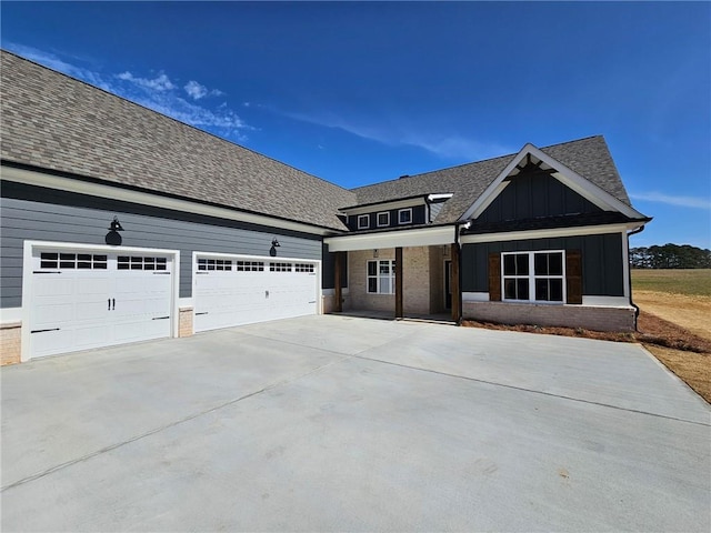 view of front of property with board and batten siding, concrete driveway, and roof with shingles