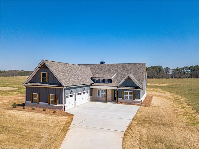 view of front of property featuring board and batten siding, a front lawn, roof with shingles, driveway, and an attached garage