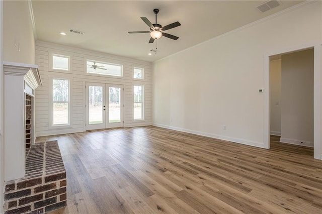 unfurnished living room featuring visible vents, ornamental molding, a ceiling fan, wood finished floors, and french doors