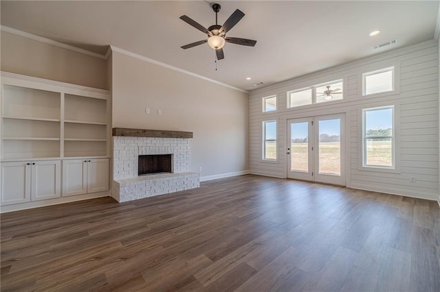 unfurnished living room featuring visible vents, ornamental molding, a fireplace, a ceiling fan, and dark wood-style flooring