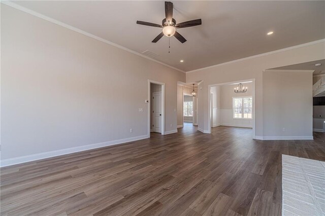 unfurnished living room with visible vents, ceiling fan with notable chandelier, dark wood-style floors, crown molding, and baseboards