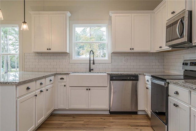 kitchen featuring a sink, light wood-style floors, white cabinetry, and stainless steel appliances